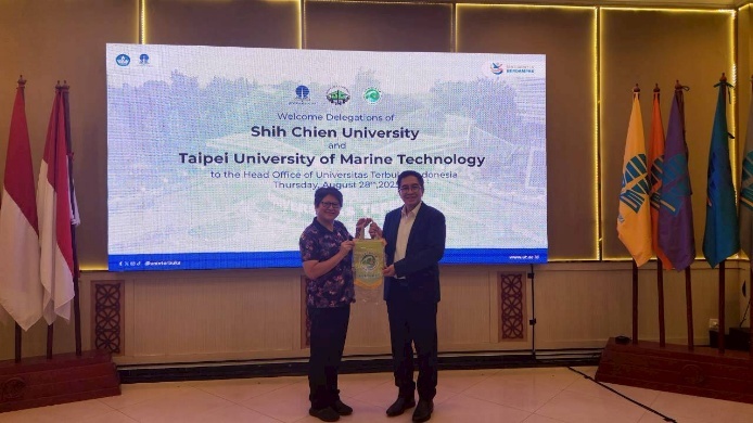 謝宜芳副教授代表本校贈旗予印尼開放大學副校長Prof. Rahmat Budiman