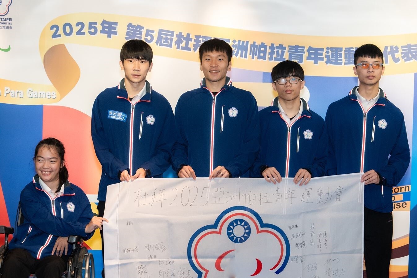 亞洲帕拉青年運動會返國餐會，由本校吳俊佑(右1)選手與其他參賽選手，一同將代表團成員簽名團旗贈予李洋部長。（圖／運動部提供）