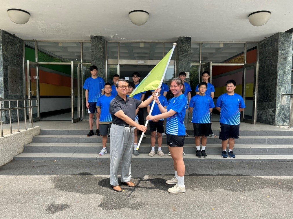 校長呂曜志（左）親手將代表旗交予去年金牌得主高佳薰（右），象徵責任與榮耀的傳承